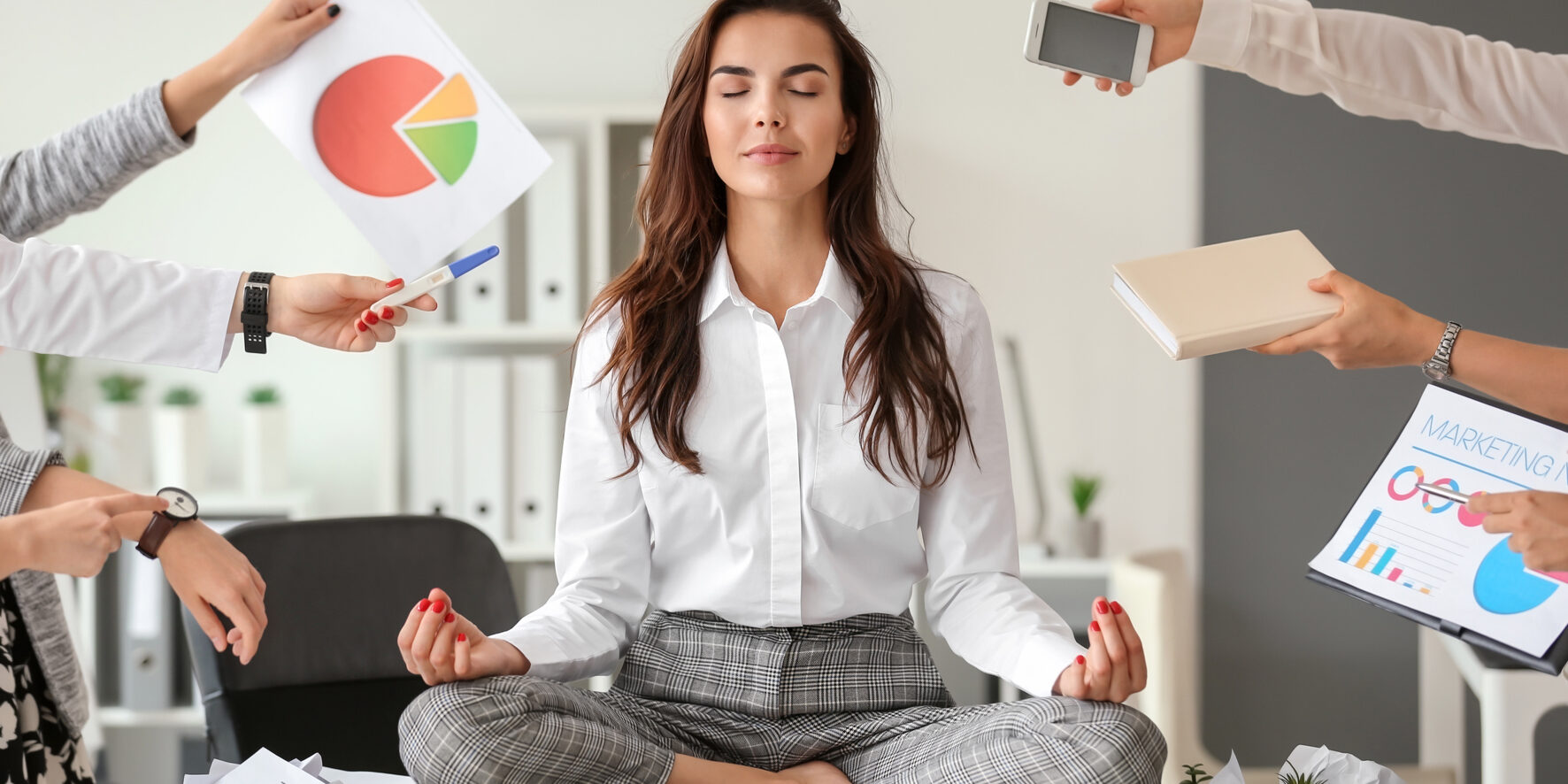 Businesswoman with a lot of work to do meditating in office